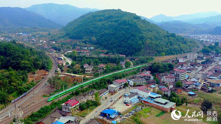 2021年9月30日，陽平關(guān)至安康跑起“復(fù)興號(hào)”動(dòng)車組，標(biāo)志秦巴深處的陽安鐵路全線邁入動(dòng)車新時(shí)代。圖為陽平關(guān)至安康“復(fù)興號(hào)”動(dòng)車在秦巴山區(qū)的崇山峻嶺間穿行。郝正國(guó)攝