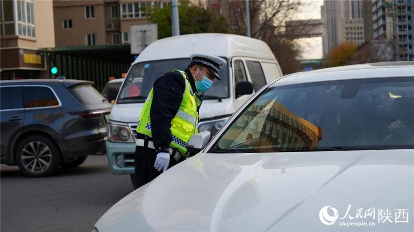 執(zhí)勤交警為群眾講解防疫政策。