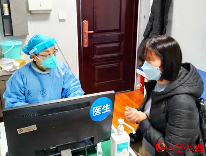 患者在新冠門診診室就診，張鴻詢問患者情況。人民網(wǎng) 鄧楠攝