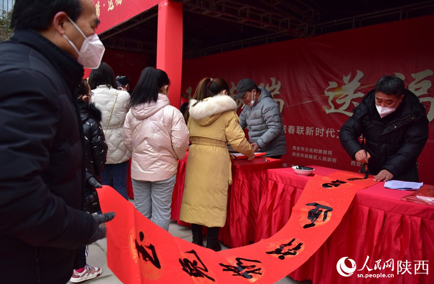 手寫春聯(lián)為群眾送上節(jié)日祝福。