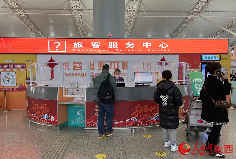 旅客服務(wù)中心內(nèi)的工作人員在耐心回答旅客問題。人民網(wǎng) 鄧楠攝