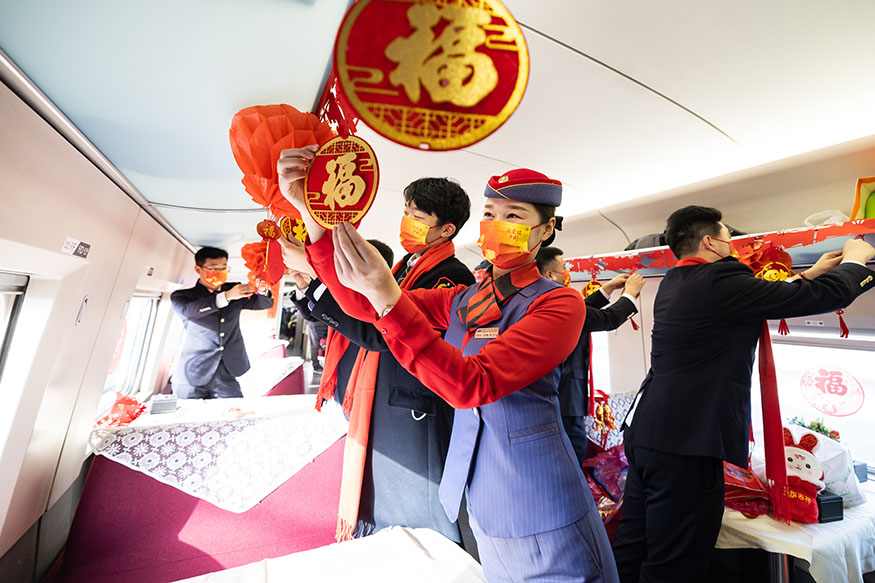 西安北至深圳北G824次列車，高鐵和地鐵乘務員一起貼窗花、掛福聯打造迎新年聯歡車廂。劉翔 攝