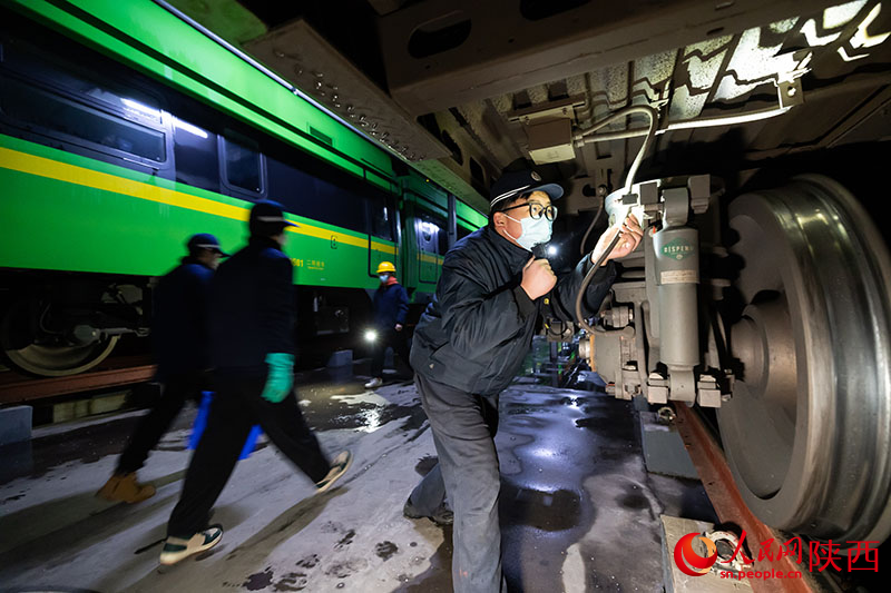 1月26日，西安客車(chē)車(chē)輛段，鐵路檢修“小哥”正在檢查動(dòng)力集中型動(dòng)車(chē)組走行部件。劉翔攝