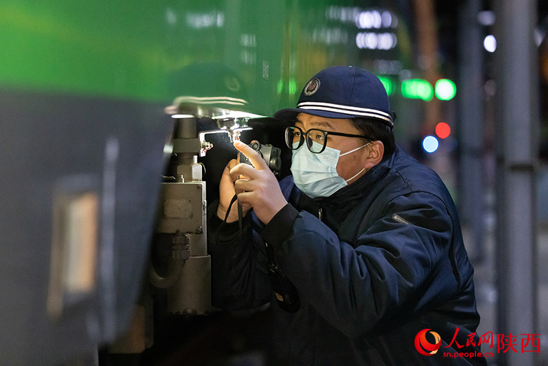 1月26日，西安客車車輛段，鐵路檢修“小哥”正在檢查動力集中型動車組注水口保證旅客正常用水。劉翔攝