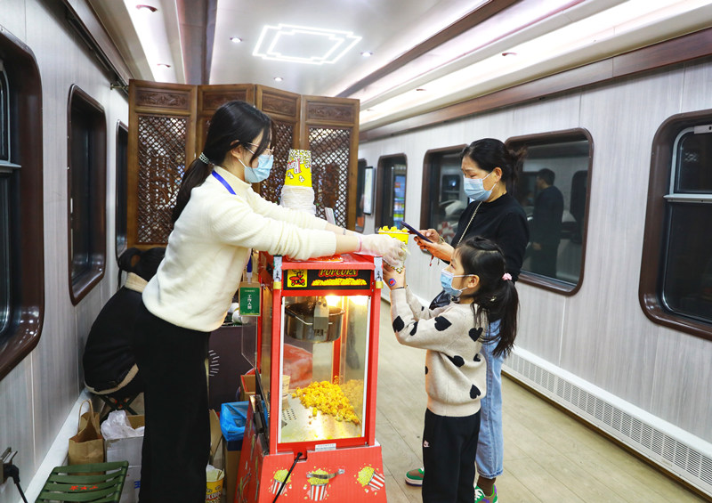 旅客們在列車上購買爆米花。敬雨橋攝