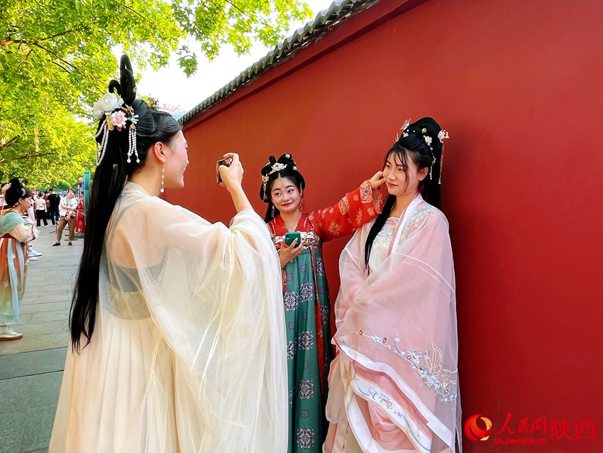 大唐不夜城景區(qū)內(nèi)，游客身著華服拍照留念。人民網(wǎng)魏鑫 攝