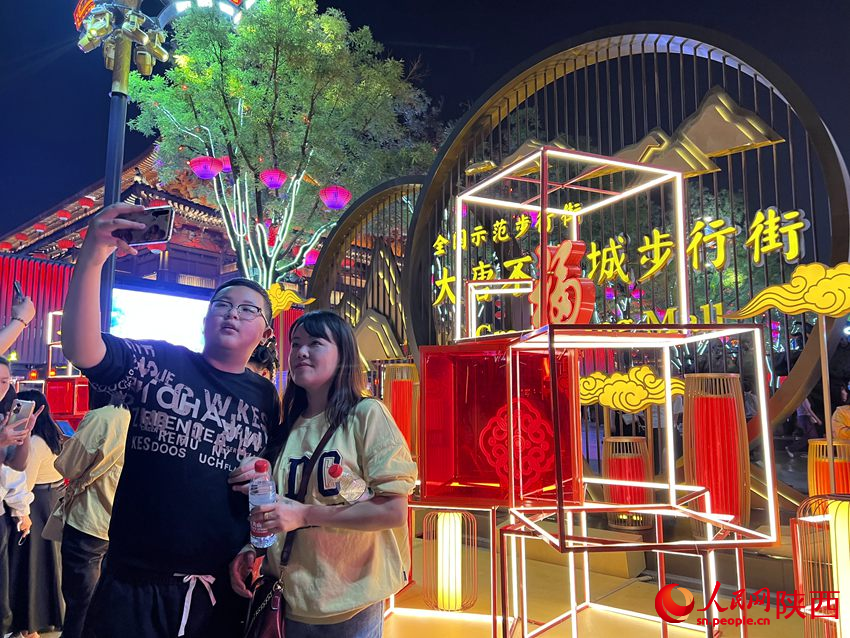 游客在大唐不夜城景區(qū)內(nèi)留影。人民網(wǎng)孫挺 攝