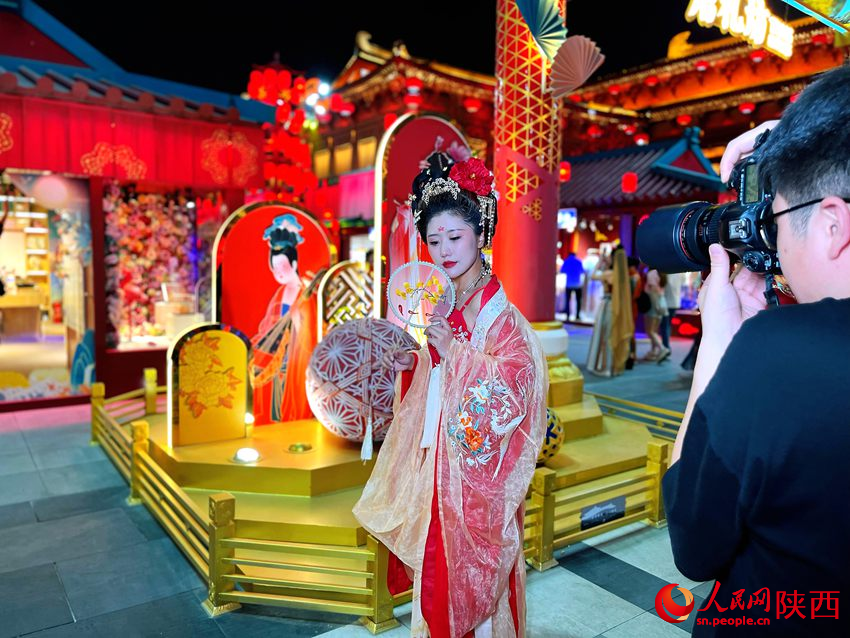 大唐不夜城景區(qū)內(nèi)，游客身著華服拍照留念。人民網(wǎng)魏鑫 攝