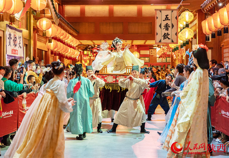 西安長安十二時(shí)辰主題街區(qū)內(nèi)表演吸引游客駐足觀看。