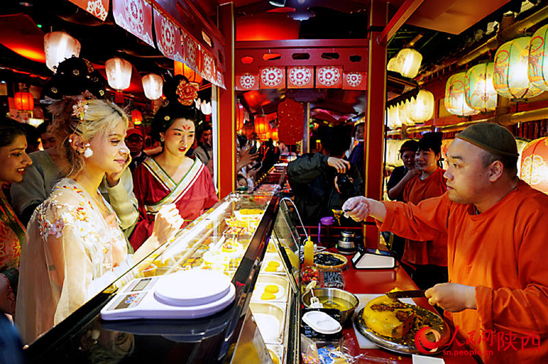 國際友人換上唐朝大袖，與街區(qū)小販互動(dòng)。