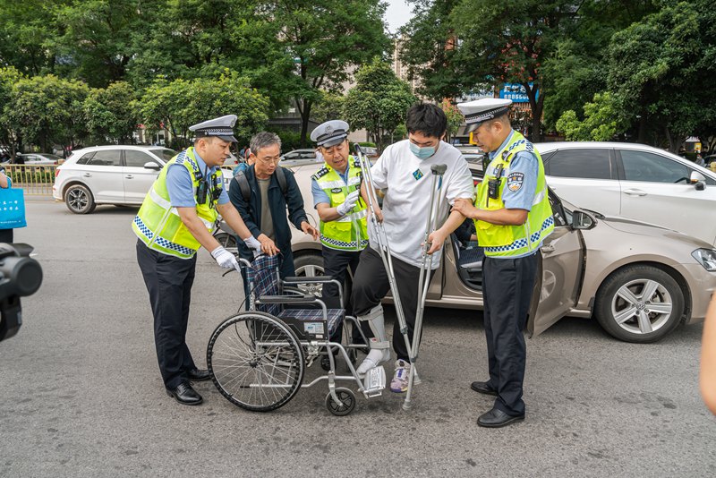 考生坐輪椅赴考，西安交警合力護(hù)送。孫崇明 攝