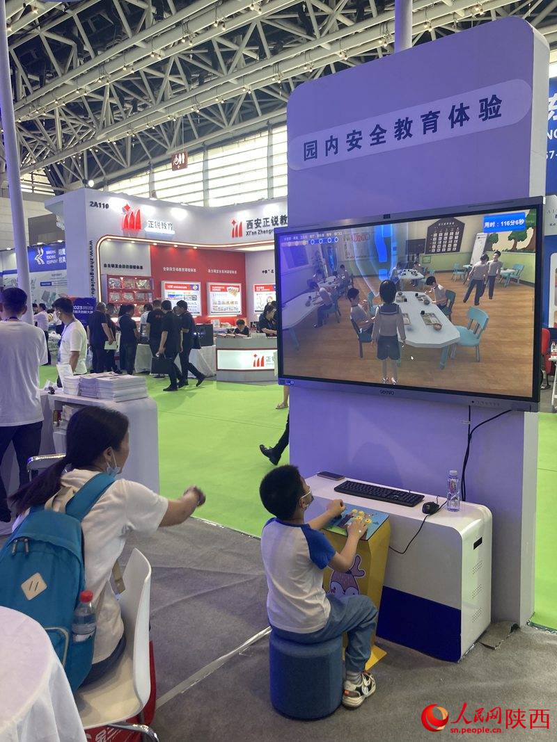 一位媽媽在陪兒子體驗(yàn)安全教育模擬裝備。 人民網(wǎng) 吳德鋒攝