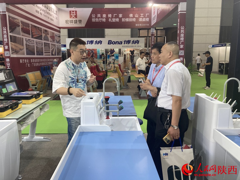 兩位觀眾在了解實驗教學儀器。 人民網(wǎng) 吳德鋒攝