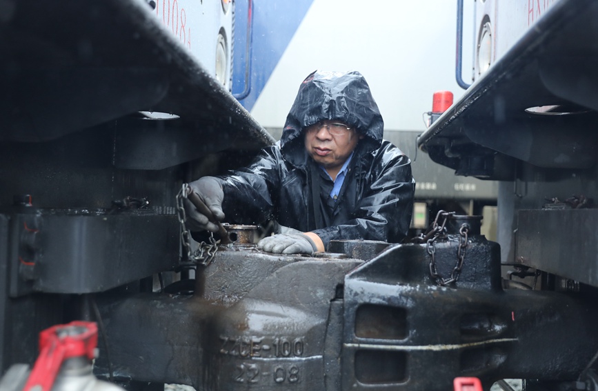 安康機(jī)務(wù)段庫內(nèi)，調(diào)車員在雨中進(jìn)行機(jī)車連掛作業(yè)。劉衛(wèi)東攝