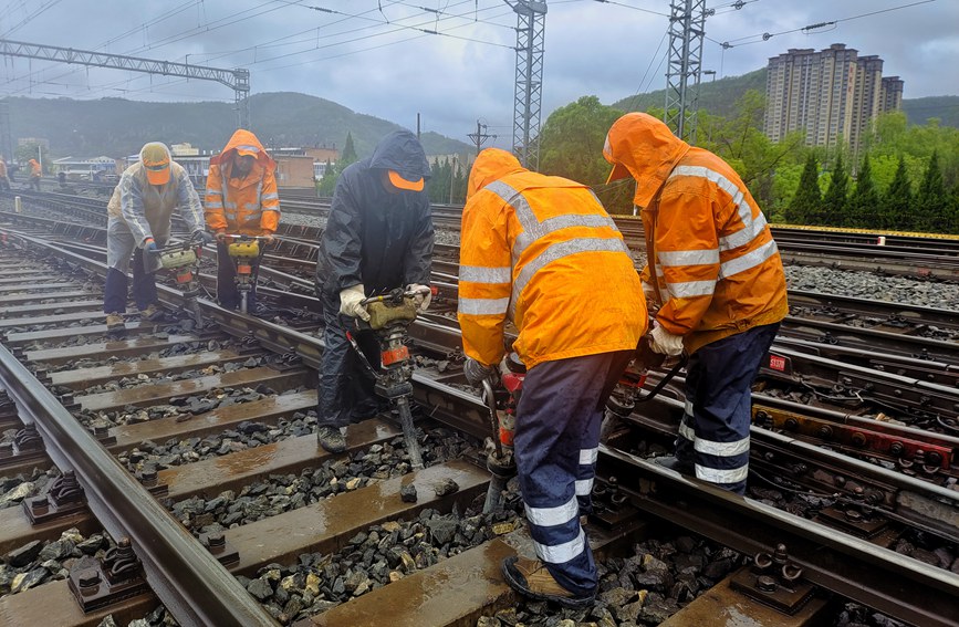 延安工務段職工雨中對線路幾何尺寸不良處所進行整治。劉一帆攝