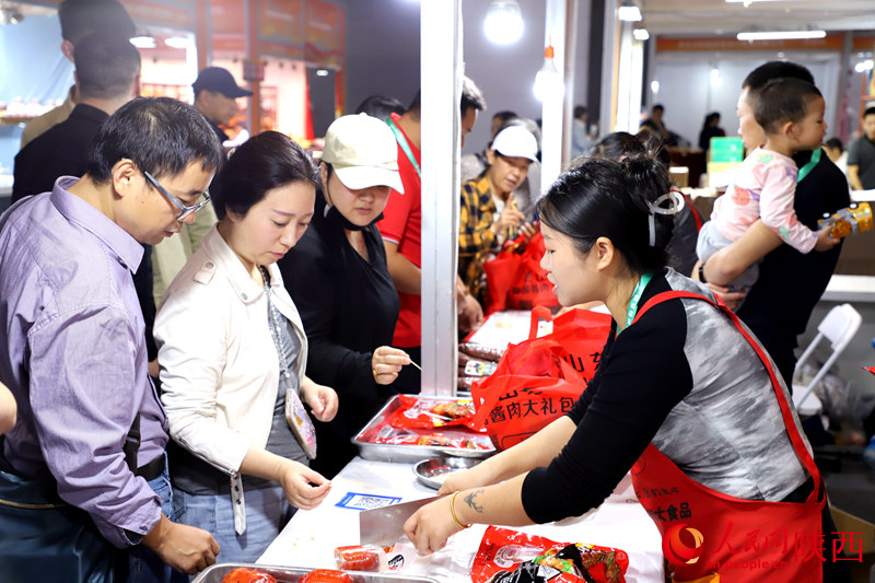 展區(qū)內(nèi)工作人員向游客推介產(chǎn)品。人民網(wǎng)記者 李志強(qiáng)攝