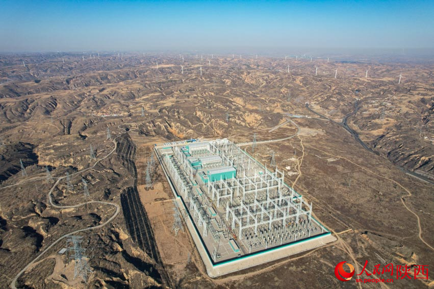 換流站和遠(yuǎn)方林立的風(fēng)力發(fā)電機。 人民網(wǎng) 黨童攝