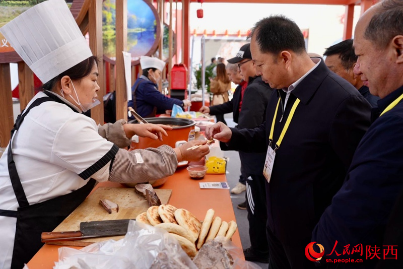 參展觀眾在渭南展館品嘗特色美食。人民網(wǎng)記者 鄒星攝