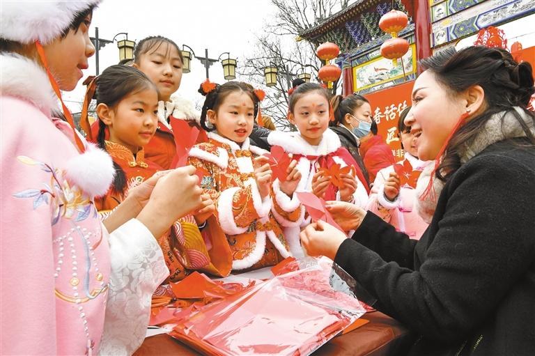 1月20日，西安永興坊·陜西非遺文化特色街區(qū)內，非遺傳承人給孩子們教授剪紙、捏面人等非遺技藝。杜瑋攝