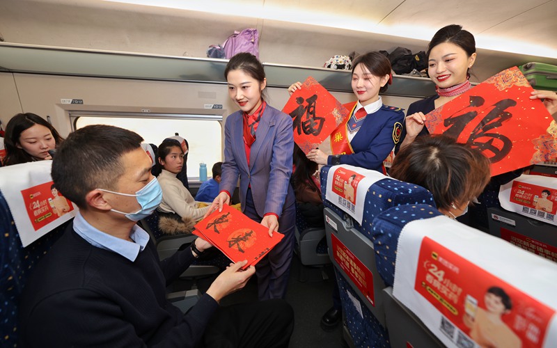 列車(chē)工作人員為旅客送上新春對(duì)聯(lián)。劉松霖 攝
