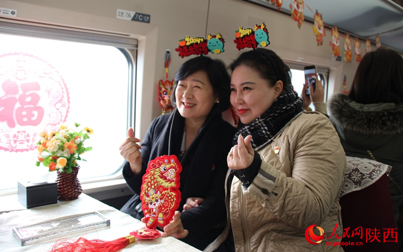 旅客們在列車內(nèi)拍照打卡，喜迎新春。人民網(wǎng)記者 賈凱璐攝