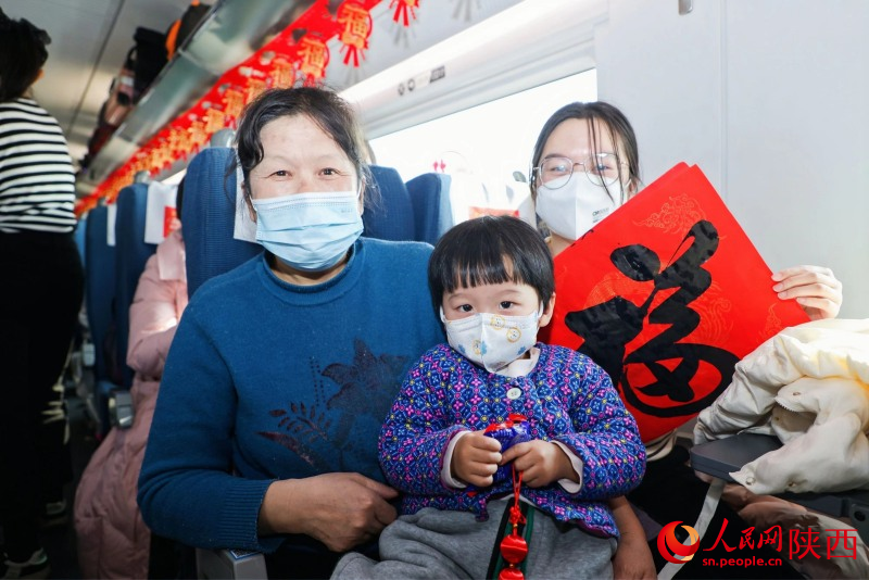 1月26日，春運(yùn)首日。西安市“致敬奮斗者·溫暖回家路”平安返鄉(xiāng)愛心專列開行。旅客在精心布置的車廂內(nèi)合影。