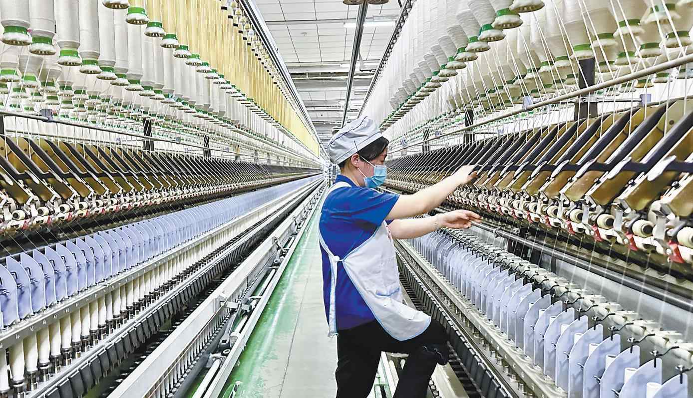 二月十八日，在咸陽紡織集團有限公司一分廠細紗車間，紡織女工在進行接頭、換粗紗等工作。 記者 琚鵬飛攝
