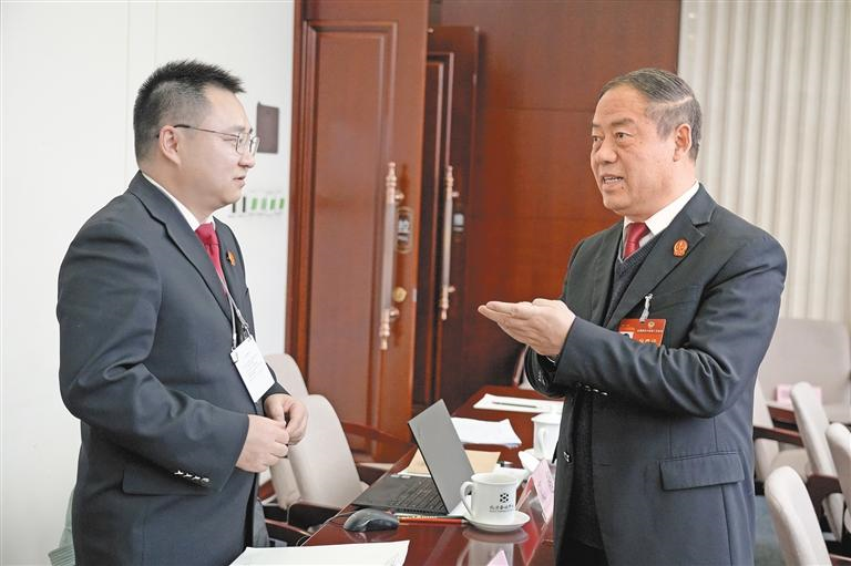 3月8日，全國(guó)政協(xié)委員鞏富文（右）與列席會(huì)議的政法部門工作人員進(jìn)行交流。孫鵬攝