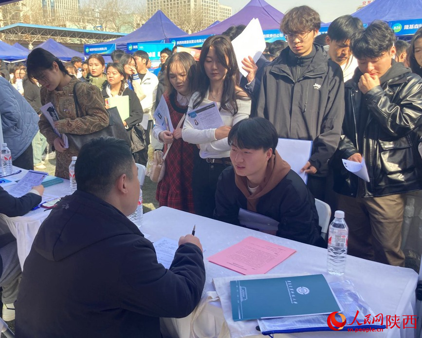 學(xué)生在與招聘人員交流。 人民網(wǎng) 吳德鋒攝