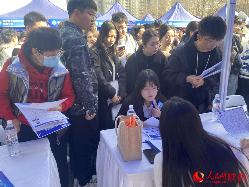 學(xué)生在與招聘人員交流。 人民網(wǎng) 吳德鋒攝
