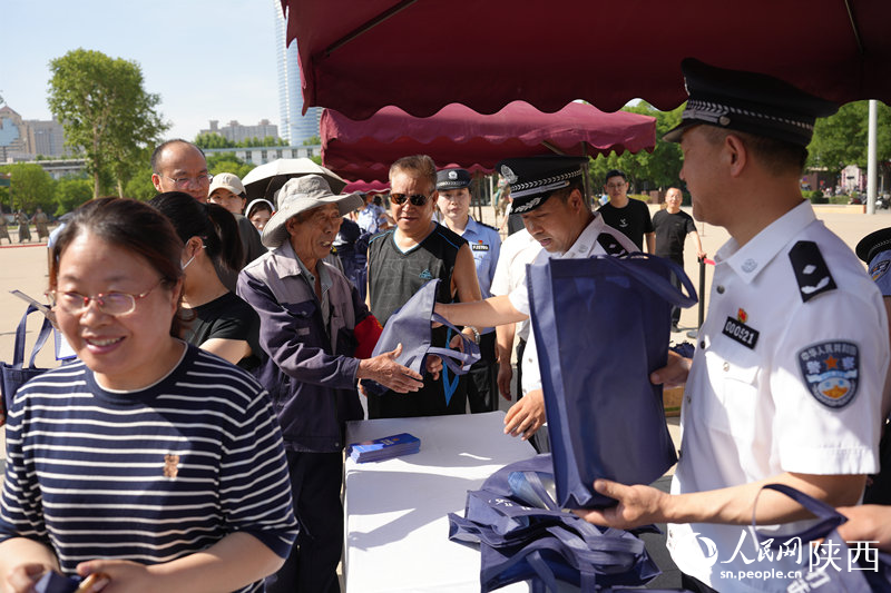 民警為群眾發(fā)放宣傳品。人民網(wǎng)記者 李志強(qiáng)攝