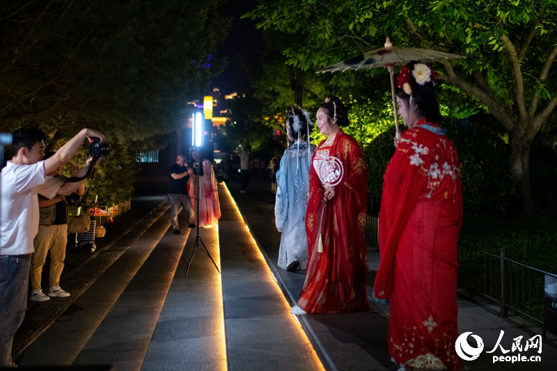 在西安大唐不夜城景區(qū)，身著漢唐服飾的游客正在拍攝寫真。人民網(wǎng)記者 翁奇羽攝