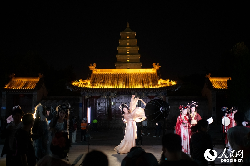 在西安大唐不夜城景區(qū)，身著漢唐服飾的游客正在拍攝寫真。人民網(wǎng)記者 翁奇羽攝