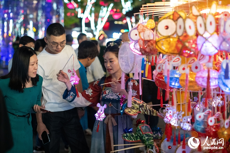 在西安大唐不夜城步行街，游客正在選購手工藝品。人民網(wǎng)記者 翁奇羽攝
