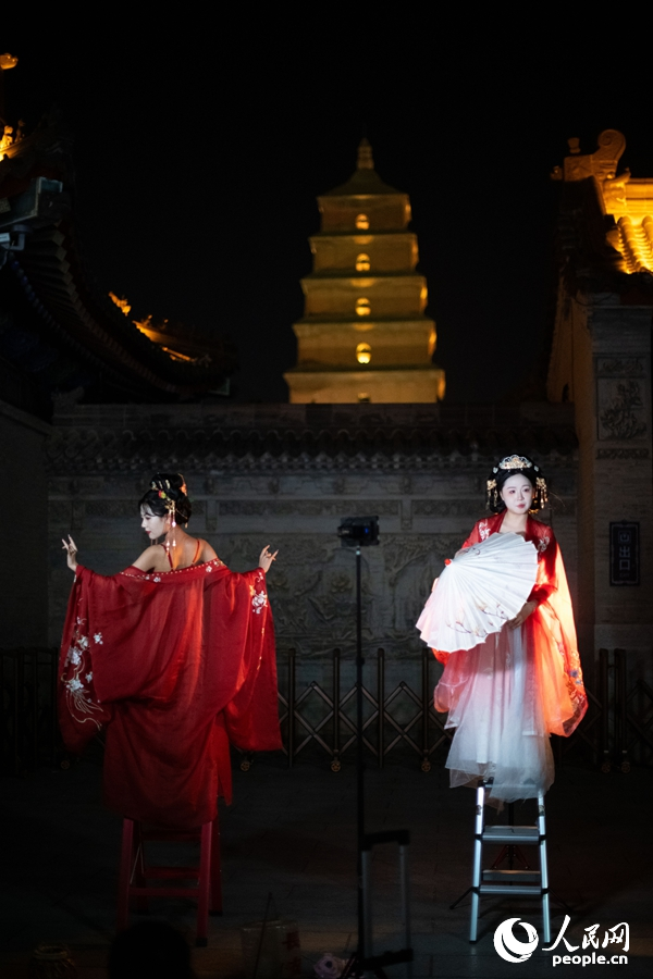 在西安大唐不夜城景區(qū)，身著漢唐服飾的游客正在拍攝寫真。人民網(wǎng)記者 翁奇羽攝