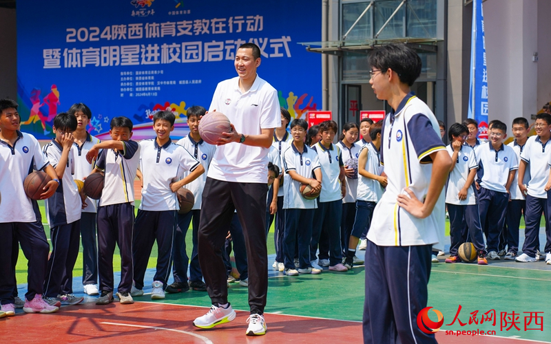 籃球CBA冠軍鄭準(zhǔn)與學(xué)生們打籃球。人民網(wǎng) 黨童攝
