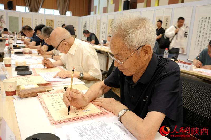退休教師用毛筆書寫2024級(jí)新生錄取通知書。人民網(wǎng)記者 賈凱璐攝