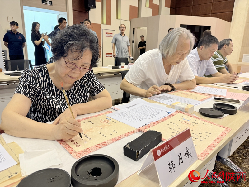 退休教師用毛筆為今年新生手寫錄取通知書。人民網(wǎng)記者 賈凱璐攝