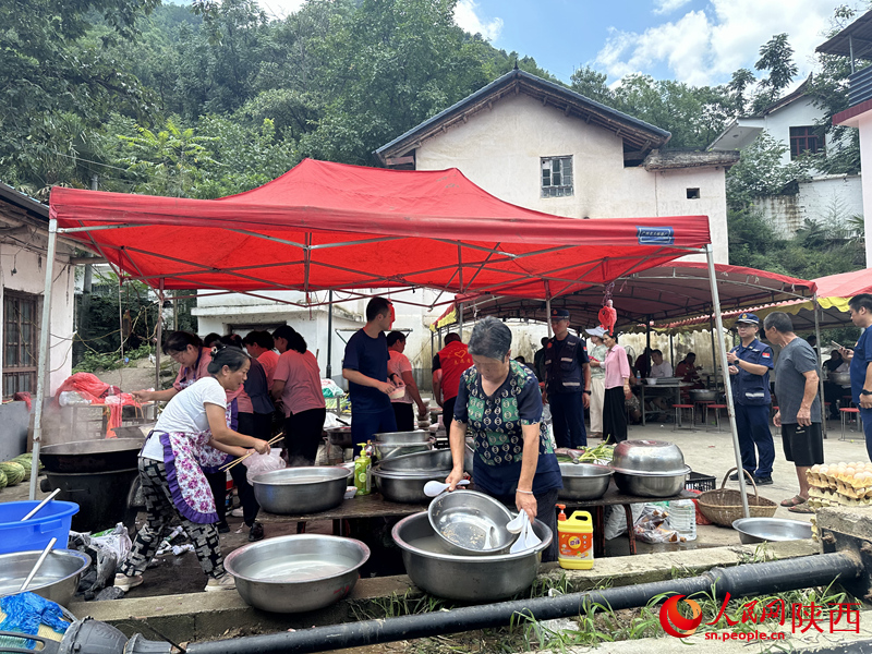 村民在應(yīng)急救援服務(wù)點(diǎn)為救援人員做后勤保障工作。人民網(wǎng)記者 李志強(qiáng)攝