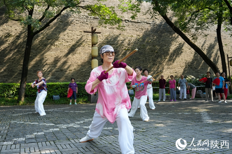市民在西安城墻下的環(huán)城公園內(nèi)練習(xí)龍形鞭桿。李欣宇 攝