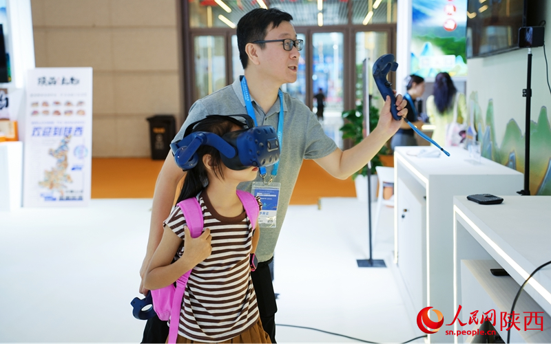 小女孩在陜西展廳內(nèi)體驗(yàn)VR項(xiàng)目。人民網(wǎng)記者 白鴿攝