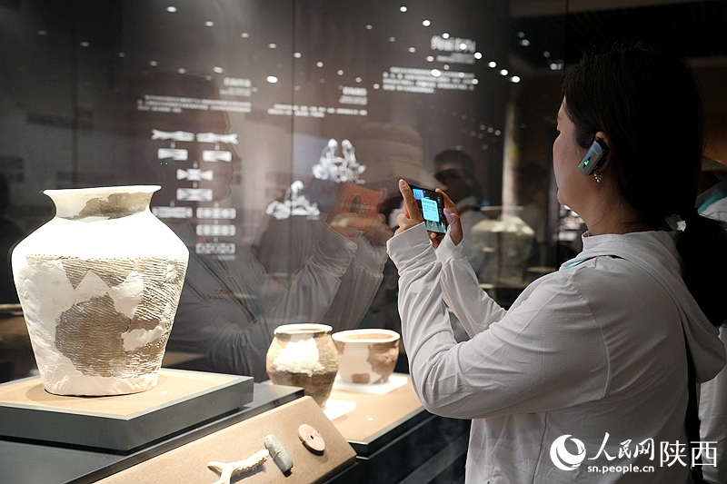 文物展柜前，游客拍照打卡。人民網(wǎng)記者 賈凱璐攝