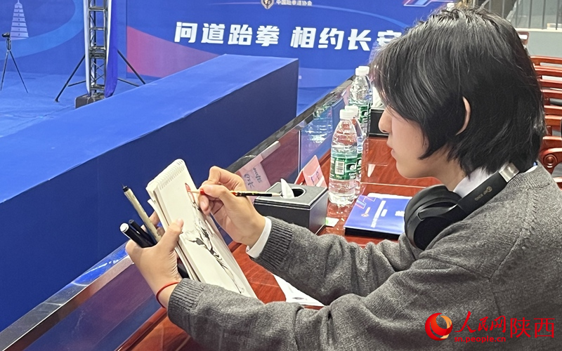 跆拳道比賽現(xiàn)場，觀眾現(xiàn)場作畫。人民網(wǎng)記者 白鴿攝