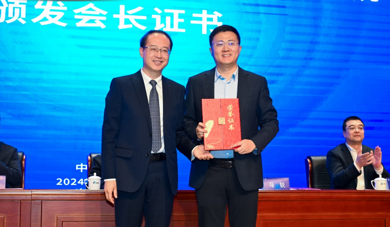 西安市體育局黨組書記、局長馬銳為新當(dāng)選的會長孟志遠(yuǎn)頒發(fā)聘書。