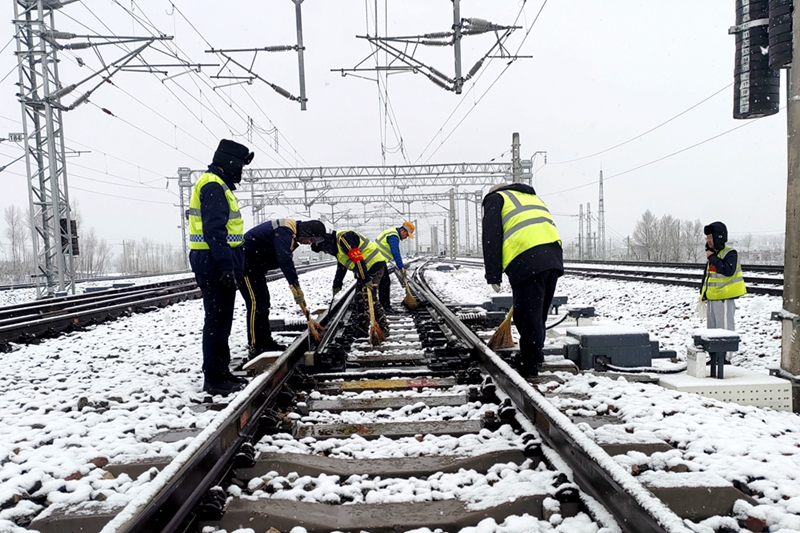 西安鐵路局綏德工電段神木西綜合維修車間職工正在進(jìn)行掃雪除冰作業(yè)。劉盼利  攝