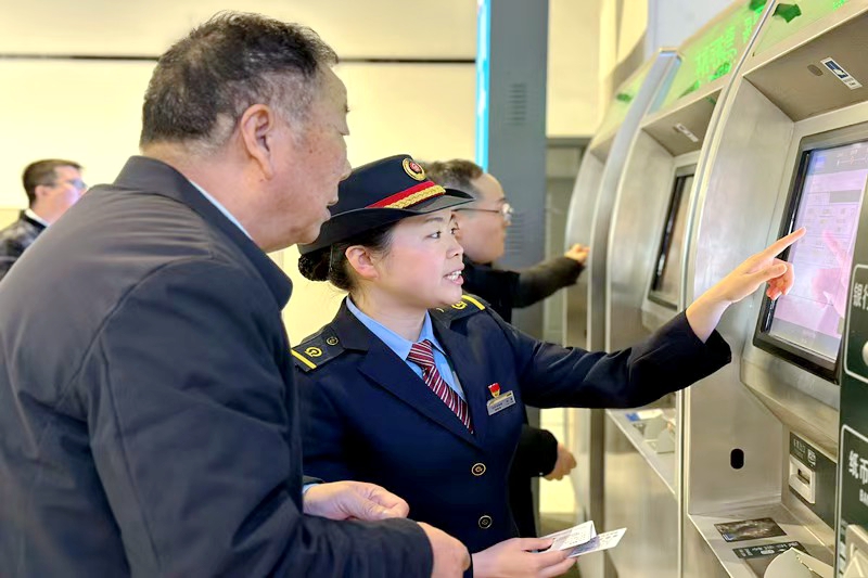 車站工作人員正在指導(dǎo)旅客購買車票。陳燕 攝