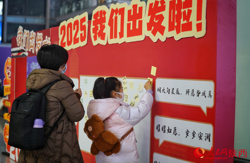 候車旅客在2025年打卡墻前寫下新年祝福。人民網(wǎng)記者 賈凱璐攝