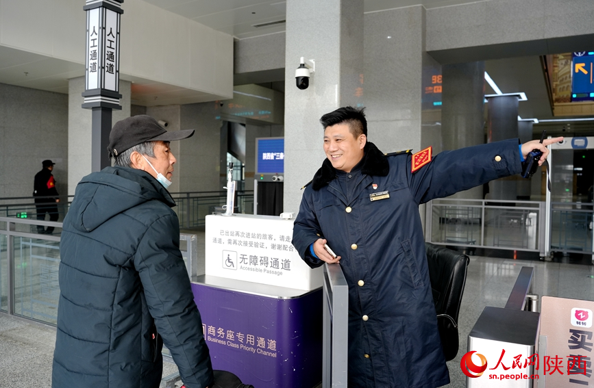 西安站工作人員為旅客指路。人民網(wǎng)記者 賈凱璐攝