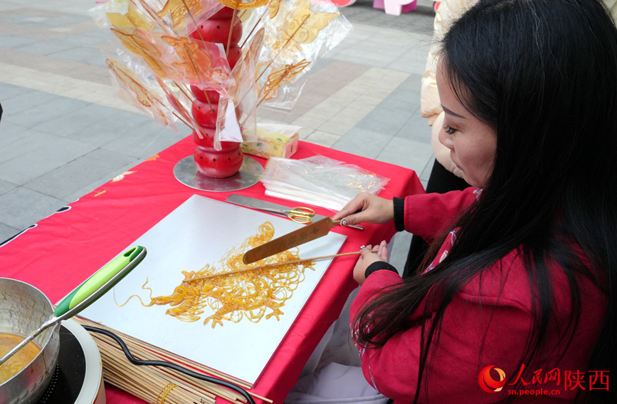 非遺傳承人現(xiàn)場(chǎng)制作糖畫。人民網(wǎng)記者 賈凱璐攝
