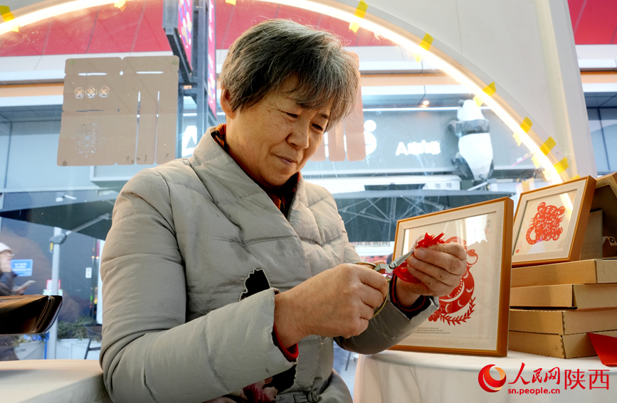 非遺傳承人展示剪紙藝術(shù)。人民網(wǎng)記者 賈凱璐攝